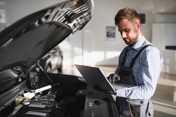 Fototapete - Mechanic Uses a Computer with an Augmented Reality Diagnostics Software. Specialist Inspecting Car's Engine to Quickly Spot Broken Components. Premium Car Service