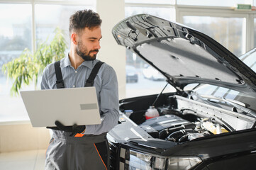 Leinwandbilder - Mechanic Uses a Computer with an Augmented Reality Diagnostics Software. Specialist Inspecting Car's Engine to Quickly Spot Broken Components. Premium Car Service
