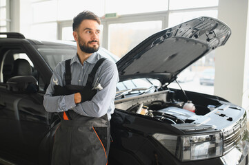 Leinwandbilder - Troubleshooting process. Auto mechanic working in garage. Repair service
