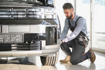 Leinwandbilder - Car mechanic working in garage and changing wheel alloy tire. Repair or maintenance auto service. Replacement of winter and summer tires
