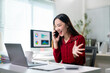 © Apichat - A woman is talking on her cell phone while sitting at a desk