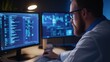 © Matthew - A focused individual analyzes data on multiple computer screens in a dimly lit environment.