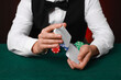 © New Africa - Professional croupier shuffling cards at gambling table, closeup