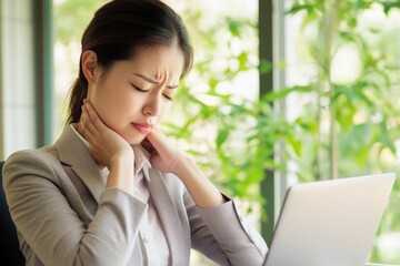 Poster - a woman sits at a table with a laptop, focused on her work