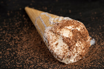 sweet melting white ice cream with chocolate chips in a waffle cone