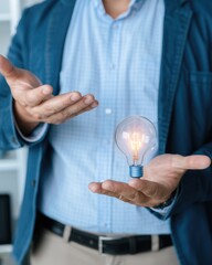 Poster - A person holding a glowing light bulb in their hands.