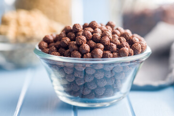 Canvas Print - Breakfast cereal chocolate balls in bowl on blue table.