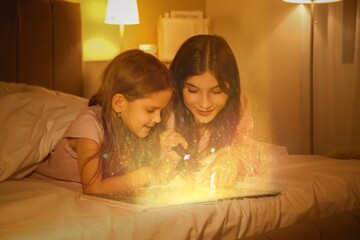 Poster - Happy mother and her little daughter with flashlight reading fairy-tale in bed at night