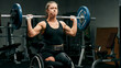 © Alesia Fes - Athlete in wheelchair lifting barbell overhead in gym. Concept of strength, freedom, mobility, discipline, drive, goal achievement, weightlifting, inclusiveness, endurance, sports, paralympic games