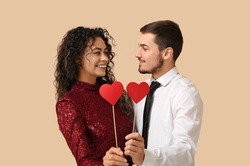 Sticker - Young couple with red hearts for Valentine's day on beige background