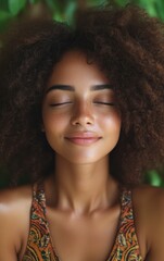 A young woman with curly hair sits peacefully with her eyes closed, enjoying tranquility amidst lush green plants. The warm light enhances her serene expression