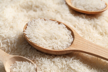 Wall Mural - Wooden spoons with raw rice, closeup