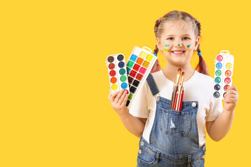 Wall Mural - Little girl with paints on yellow background