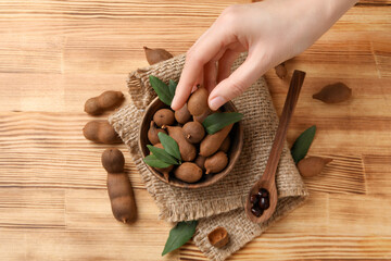 Wall Mural - Ripe tamarind with leaves in a wooden bowl