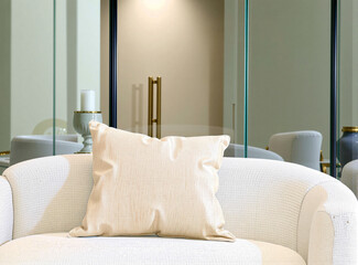 Wall Mural - Blank soft beige pillow on a soft white sofa, surrounded by reflective glass surfaces and soft, indirect lighting.