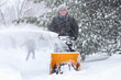 © soupstock - Man using a snowblower to clear his sidewalk and driveway