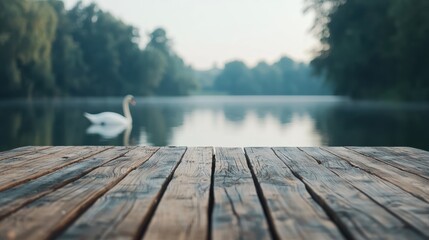 Poster - Wooden pier overlooking lake with blurred swan gliding in background