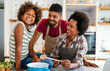 © NDABCREATIVITY - Happy black family in the kitchen having fun and cooking together. Healthy food at home.
