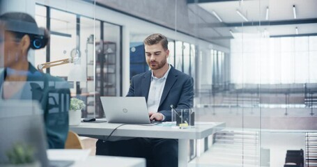 Aufkleber - Proactive Caucasian Manager Sitting Behind a Desk, Working on Laptop Computer in Office with Diverse Colleagues. Young Male Specialist Researching Financial Information for Shareholders