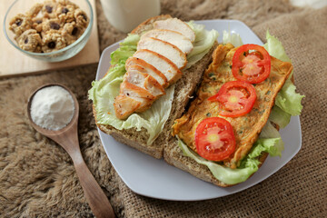 Big breakfast, bread, chicken slice, tomato, lettuce, smoked beef, egg, salad with milk. Bread sandwich fresh and healthy food meal lunch dinner breakfast slices of sandwiches.