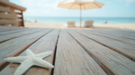 Poster - Serene beach scene featuring a wooden board in the foreground with white umbrella and starfish, soft blue ocean and sandy shore in the background.