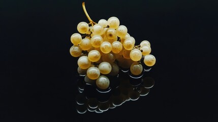 close up of a single white grape cluster with glossy reflection on a dark surface showcasing texture