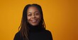 © David Giraud - Portrait d'une femme senior afro-américaine souriante avec des dreadlocks, portant un pull à col roulé noir, arrière-plan isolé de couleur orange, image avec espace pour texte.