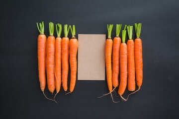 Poster - Two groups of fresh carrots arranged symmetrically on a dark surface with a blank card in between.