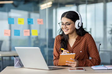 woman watching online video course, training conference inside office at workplace. office worker in