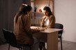 © Andrii Lysenko - Two women are playing a checkers game at home. Leisure and weekend