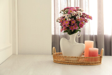 Wall Mural - Stylish vase with beautiful flowers and candles on white wooden table at home, space for text