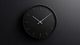 A simple black clock with silver hands on a black wall