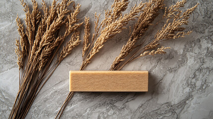 Poster - Wooden block with dried grass placed on a rustic wooden surface in natural light