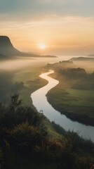 Aufkleber - Calm river winding through a serene landscape at sunrise with mist settling over the valley
