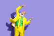 © deagreez - Portrait of funny extravagant aged man point fingers empty space ad yellow suit isolated on purple color background