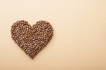 Aufkleber - Coffee beans arranged in a heart shape on a light beige background.