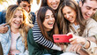 © Davide Angelini - Group of young people using smart mobile phone outdoors - Happy friends with smartphone laughing together watching funny video on social media platform - Tech and modern life style concept