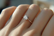 © PhotoProAD - A woman's hand holding a ring with a diamond in the center