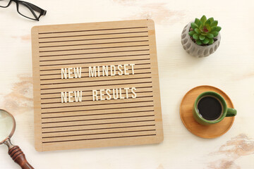 Poster - top view image of table with wooden board and the text new mindset. success and personal development concept