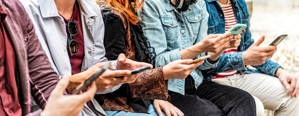 group of young people using smart mobile phone device outside - trendy technology concept with guys 
