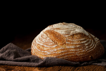 Fototapete - Crispy artisan sourdough bread on rustic wooden table
