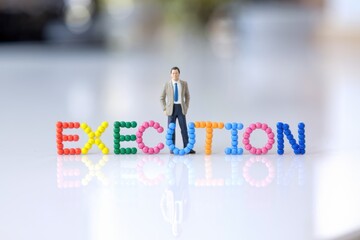 Aufkleber - A miniature businessman stands proudly before the word EXECUTION, signifying successful project completion and achievement.