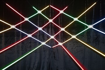 Aufkleber - Colorful neon lights arranged in a crisscross pattern on a dark background.