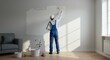 © Oxana39 - Male painting a wall in sunlit room wearing blue overalls and white cap
