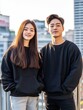 © AI Photo Stock - Couple in Black Hoodies Cityscape - A young couple smiles, wearing matching black hoodies against a city backdrop.