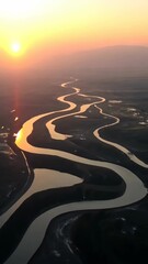 Wall Mural - Golden sunset highlights winding river in tranquil landscape during evening hours