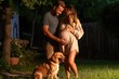 © Konstiantyn Zapylaie - Expectant caucasian couple celebrating pregnancy in backyard with golden retriever