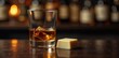 © Pusit - A single piece of milk chocolate is placed next to a whiskey glass on a dark, dimly lit bar surface, glass, darkness, whiskey