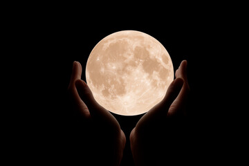 full moon held in hands against black background