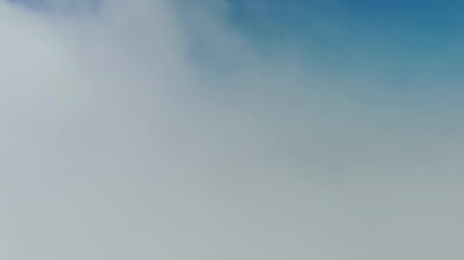 Wall Mural - flying through beautiful white fluffy clouds in sky over blue sea. airplane travel background, 4k